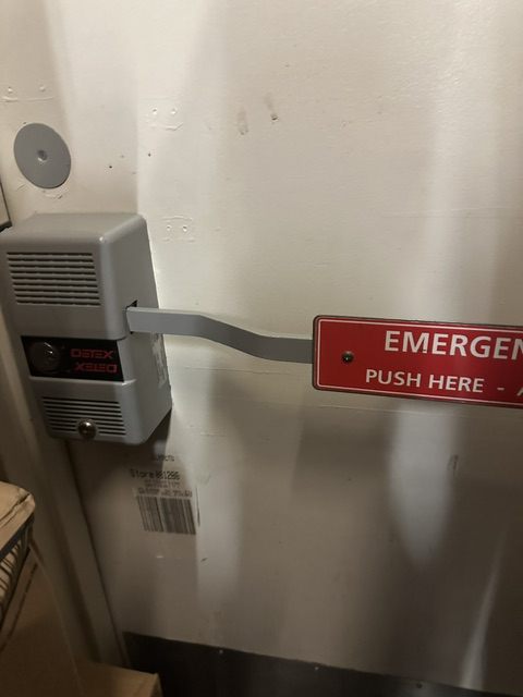 Detex alarmed exit device fitted to a commercial emergency exit door